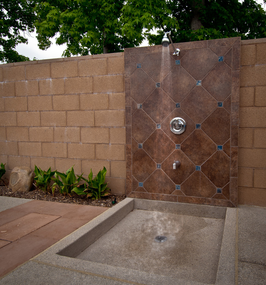Cette photo montre une terrasse avec une douche extérieure arrière exotique de taille moyenne avec une dalle de béton et aucune couverture.