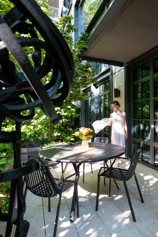 На фото: двор среднего размера на внутреннем дворе в стиле модернизм с вертикальным садом и мощением тротуарной плиткой без защиты от солнца с