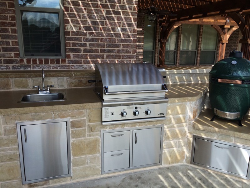 Inspiration for a large craftsman backyard concrete patio kitchen remodel in Dallas with a pergola