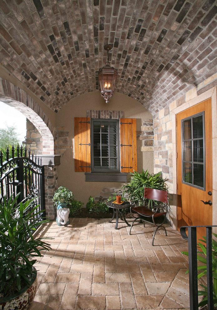 Immagine di un patio o portico mediterraneo con pavimentazioni in pietra naturale e un tetto a sbalzo