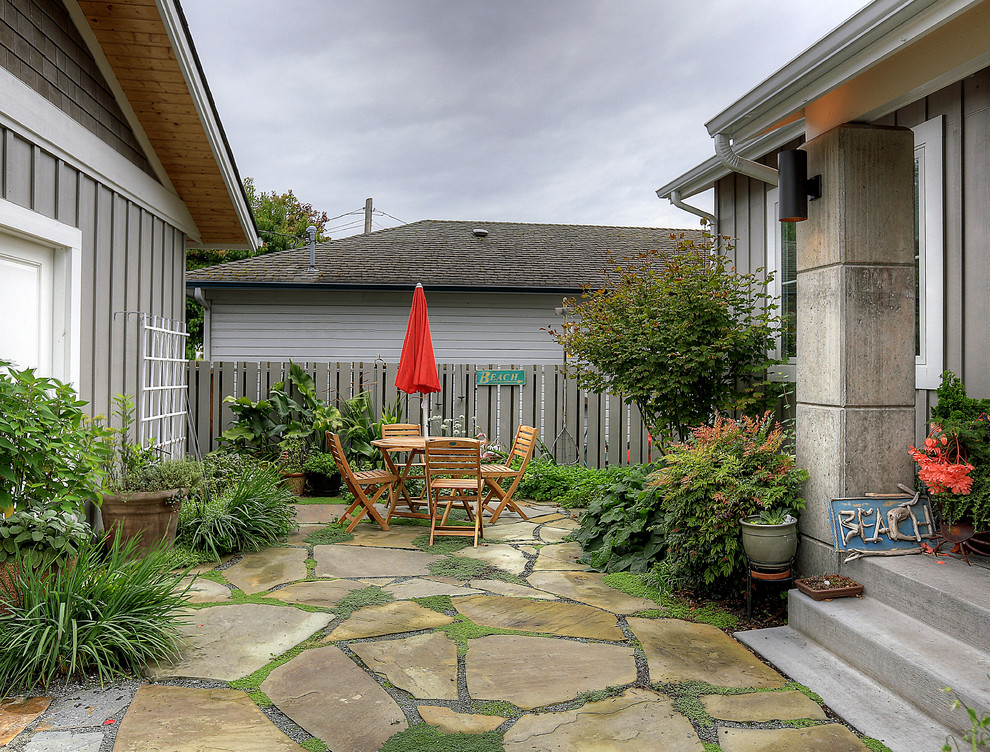 Esempio di un patio o portico stile marinaro di medie dimensioni e davanti casa con un giardino in vaso, pavimentazioni in pietra naturale e nessuna copertura