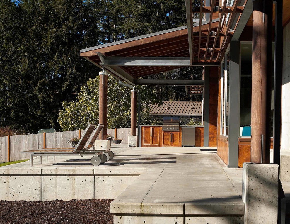 Patio kitchen - mid-sized modern front yard concrete patio kitchen idea in Seattle with a roof extension