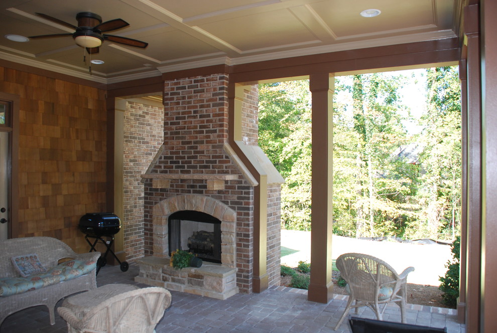 Foto de patio clásico de tamaño medio en patio trasero y anexo de casas con chimenea y adoquines de hormigón