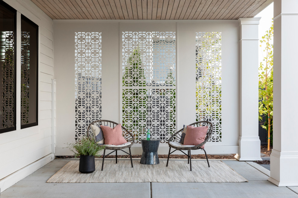 Immagine di un patio o portico chic di medie dimensioni e dietro casa con lastre di cemento