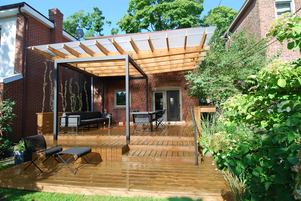 Immagine di un patio o portico minimalista con pedane e una pergola