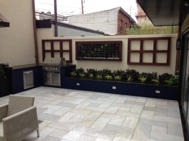 This is an example of a medium sized contemporary back patio in New York with an outdoor kitchen, tiled flooring and no cover.