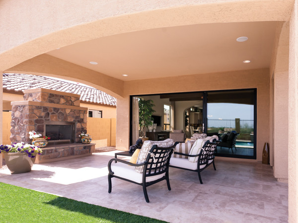 Exemple d'une terrasse arrière tendance avec un foyer extérieur, une dalle de béton et une extension de toiture.