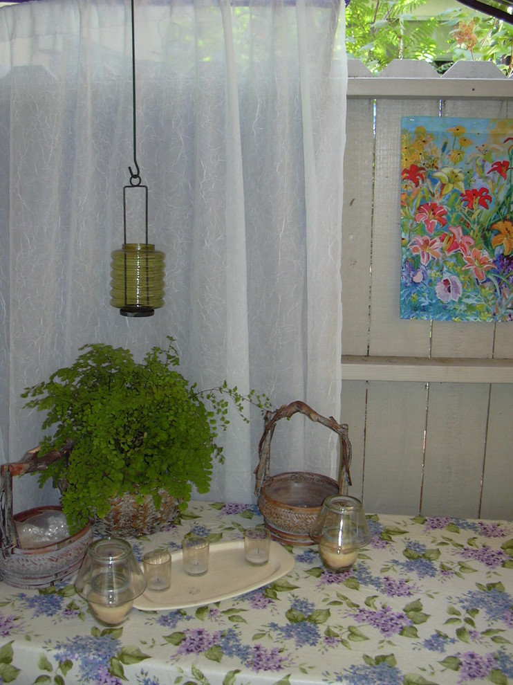 Idee per un piccolo patio o portico bohémian dietro casa con un giardino in vaso, lastre di cemento e un parasole