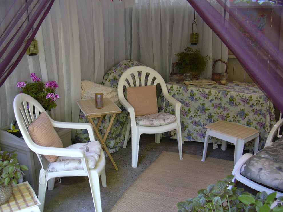 This is an example of a small bohemian back patio in Los Angeles with a potted garden, concrete slabs and an awning.