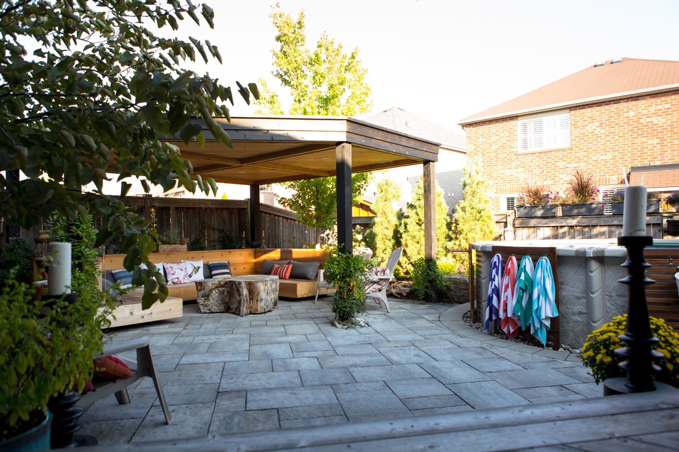 Ispirazione per un patio o portico american style di medie dimensioni e dietro casa con pavimentazioni in cemento e un gazebo o capanno