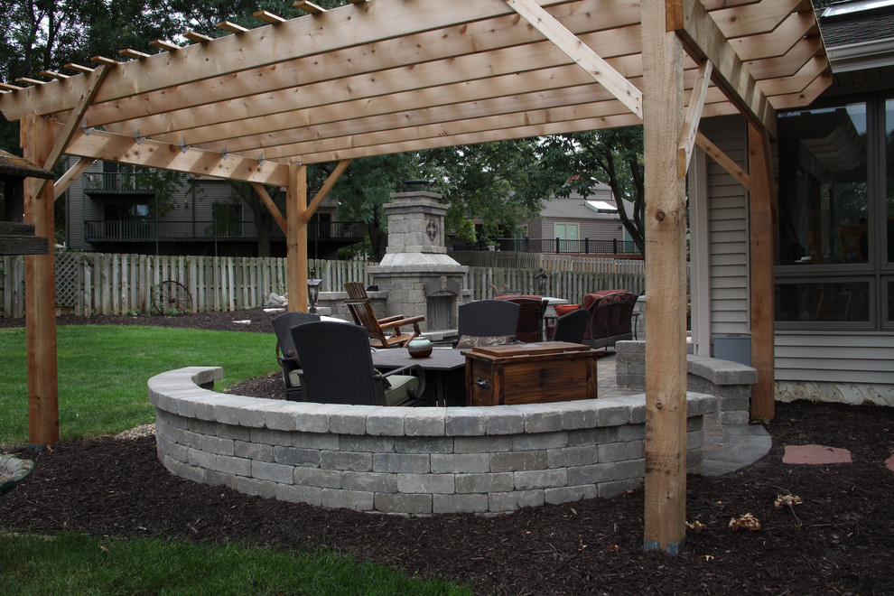 Large elegant backyard concrete paver patio photo in Omaha with a fire pit and a pergola