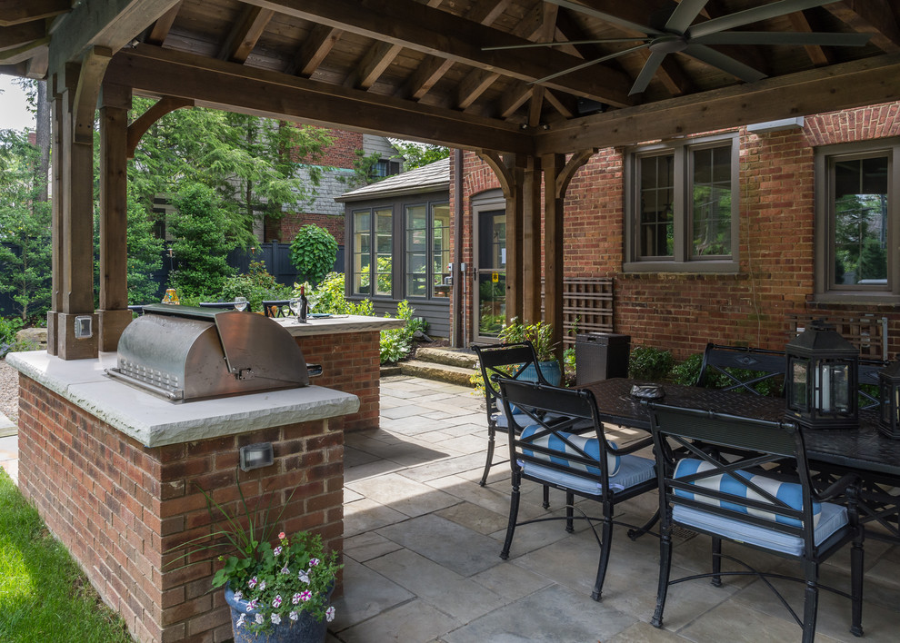 Idées déco pour une grande terrasse arrière classique avec une cuisine d'été, des pavés en pierre naturelle et un gazebo ou pavillon.