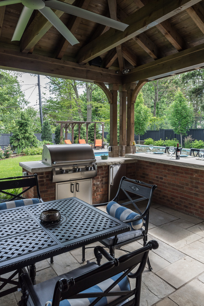 Großer Klassischer Patio hinter dem Haus mit Outdoor-Küche, Natursteinplatten und Gazebo in Cleveland