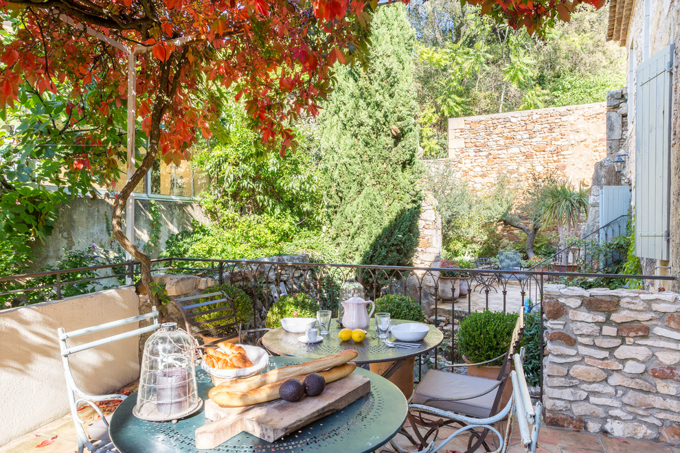 Cette image montre une terrasse avec des plantes en pots méditerranéenne de taille moyenne avec aucune couverture et du carrelage.