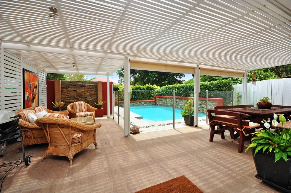 Example of a trendy backyard tile patio design in Brisbane with a pergola