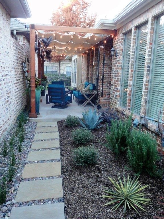 Idee per un piccolo patio o portico chic nel cortile laterale con un focolare, pavimentazioni in cemento e un parasole