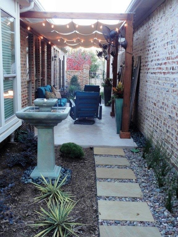 Пример оригинального дизайна: маленький двор на боковом дворе в стиле неоклассика (современная классика) с местом для костра, мощением тротуарной плиткой и козырьком для на участке и в саду