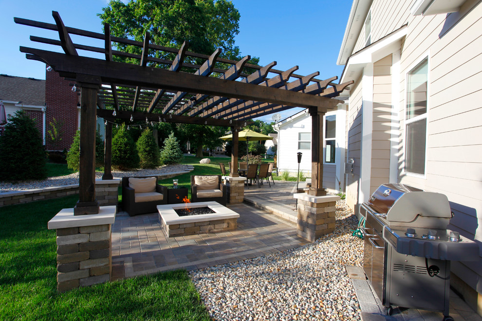 Esempio di un piccolo patio o portico tradizionale dietro casa con un focolare, pavimentazioni in cemento e una pergola