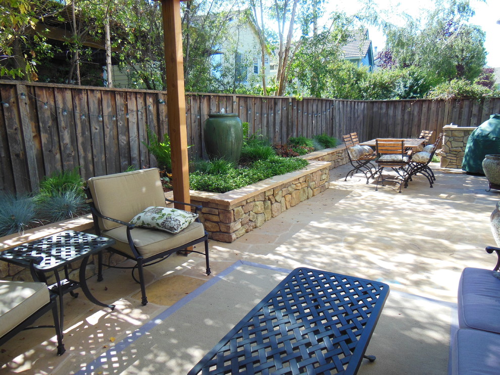 Immagine di un piccolo patio o portico classico dietro casa con pavimentazioni in pietra naturale e una pergola