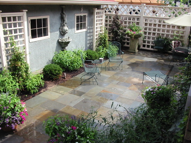 Foto di un patio o portico american style di medie dimensioni e nel cortile laterale con fontane e pavimentazioni in mattoni