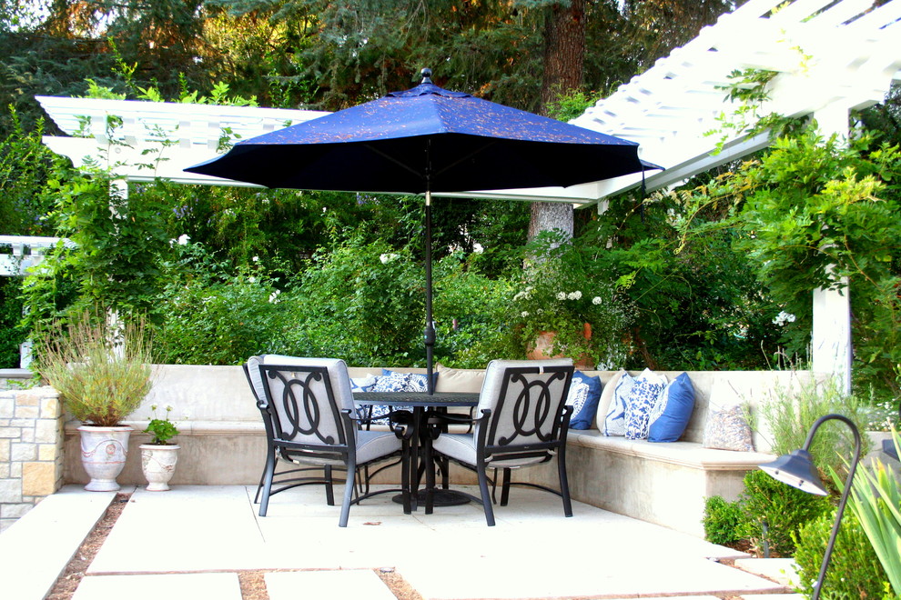 Example of a mid-sized trendy backyard concrete patio fountain design in Los Angeles with a pergola