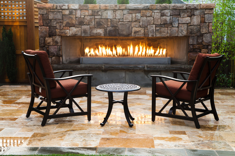This is an example of a small traditional back patio in DC Metro with a fire feature and natural stone paving.