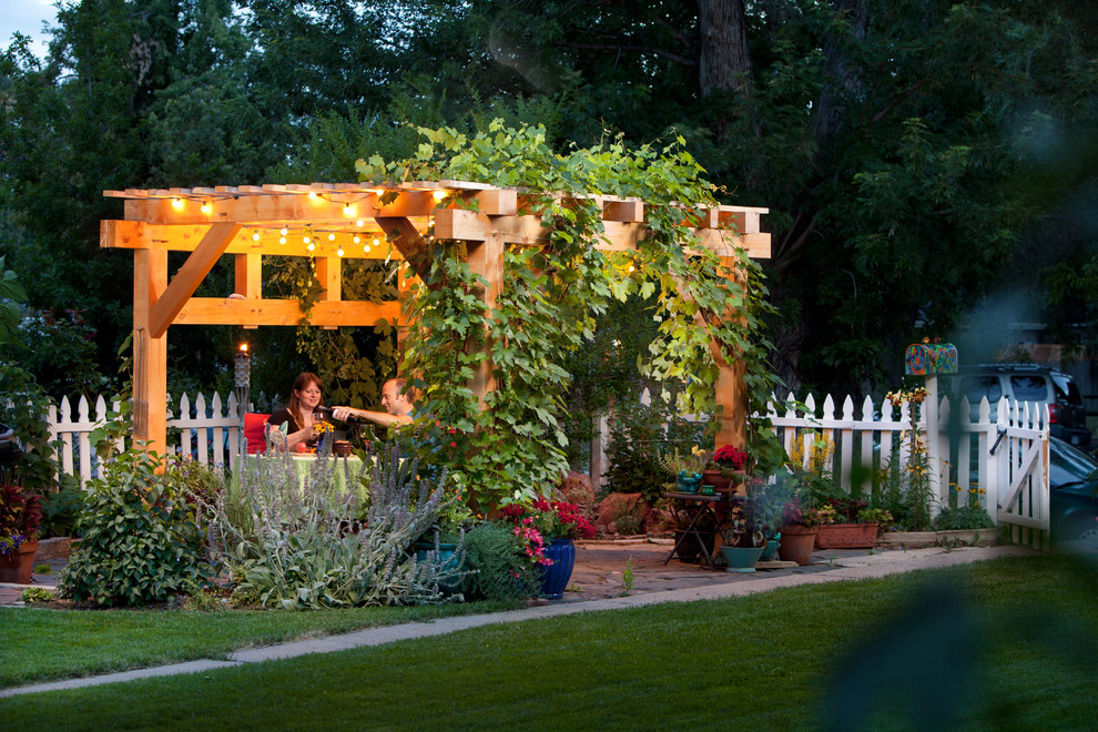 Imagen de patio de estilo americano de tamaño medio en patio trasero con pérgola y adoquines de piedra natural