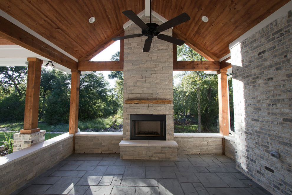 Aménagement d'une terrasse arrière classique de taille moyenne avec une cheminée, du béton estampé et une extension de toiture.
