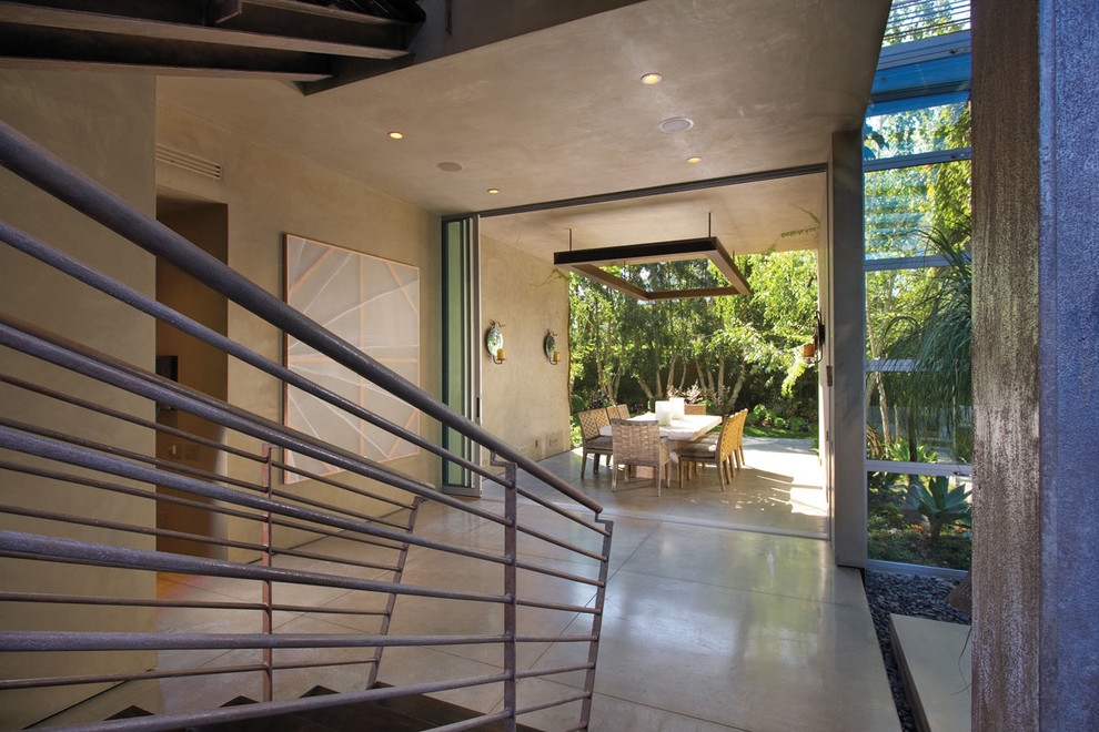 This is an example of a contemporary patio in Orange County with a roof extension.