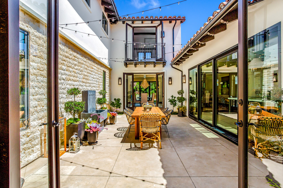 Mediterranean courtyard patio in Orange County with a water feature, no cover and concrete slabs.