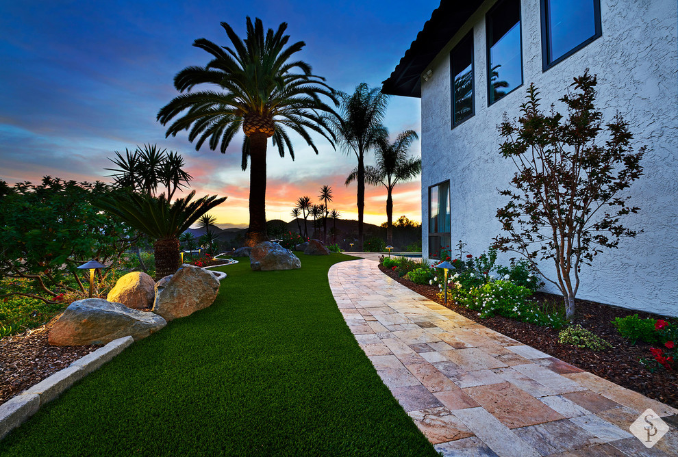 Patio - huge mediterranean side yard stone patio idea in Orange County