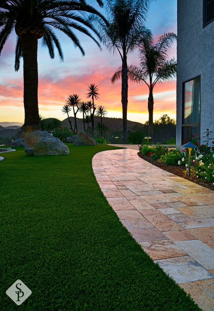 Idee per un ampio patio o portico mediterraneo nel cortile laterale con pavimentazioni in pietra naturale