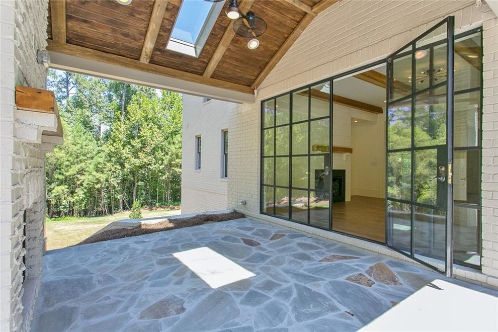 Patio - mid-sized country backyard stone patio idea in Atlanta with a fireplace and a roof extension