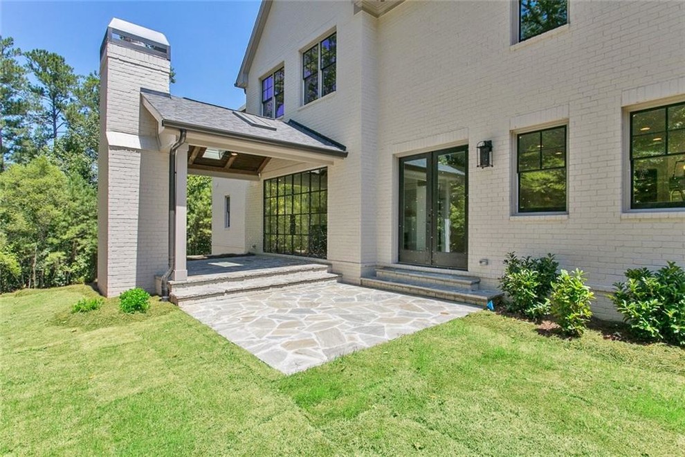 Mid-sized country backyard stone patio photo in Atlanta with a fireplace and a roof extension