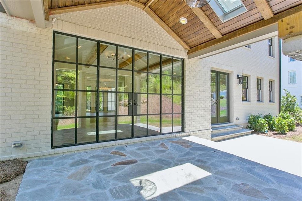 Inspiration for a mid-sized farmhouse backyard stone patio remodel in Atlanta with a fireplace and a roof extension
