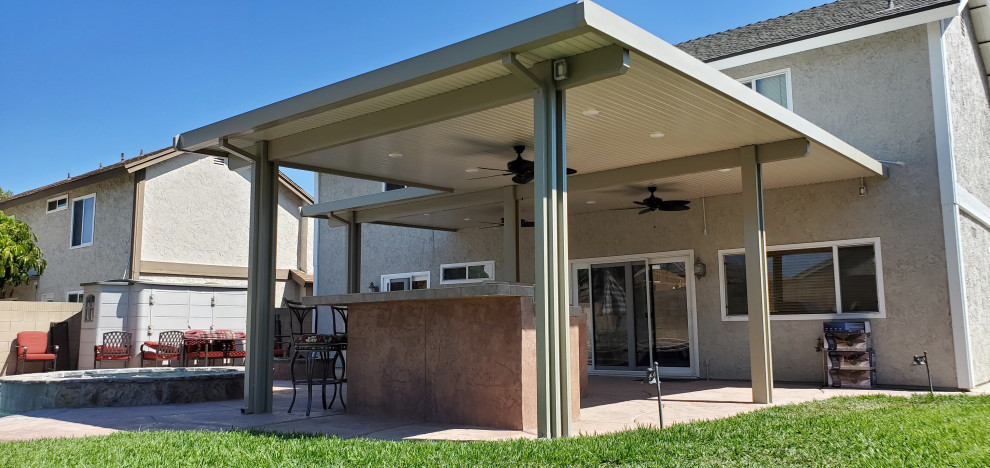 Idee per un grande patio o portico classico dietro casa con cemento stampato e un gazebo o capanno