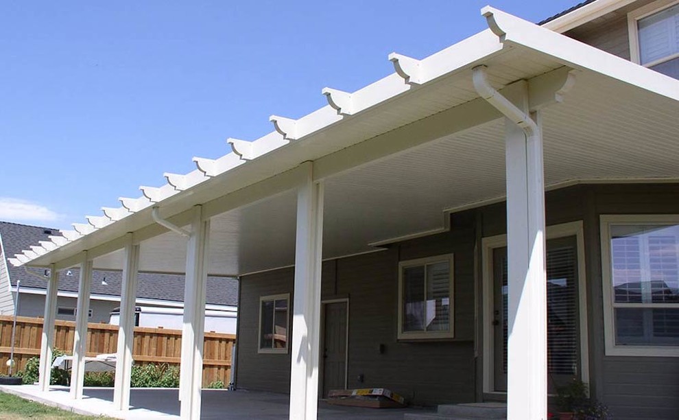Foto di un grande patio o portico tradizionale dietro casa con un tetto a sbalzo e lastre di cemento