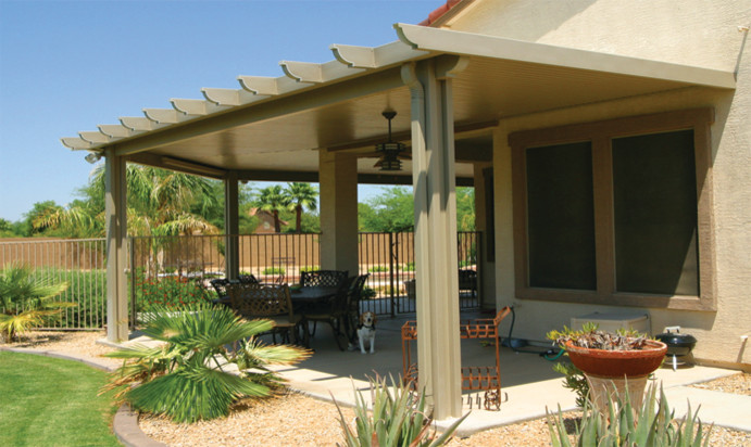 Immagine di un piccolo patio o portico tropicale dietro casa con lastre di cemento e un tetto a sbalzo
