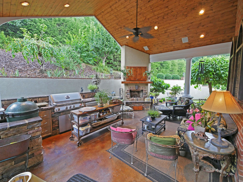 Inspiration pour une grande terrasse arrière traditionnelle avec une cuisine d'été, du béton estampé et une extension de toiture.