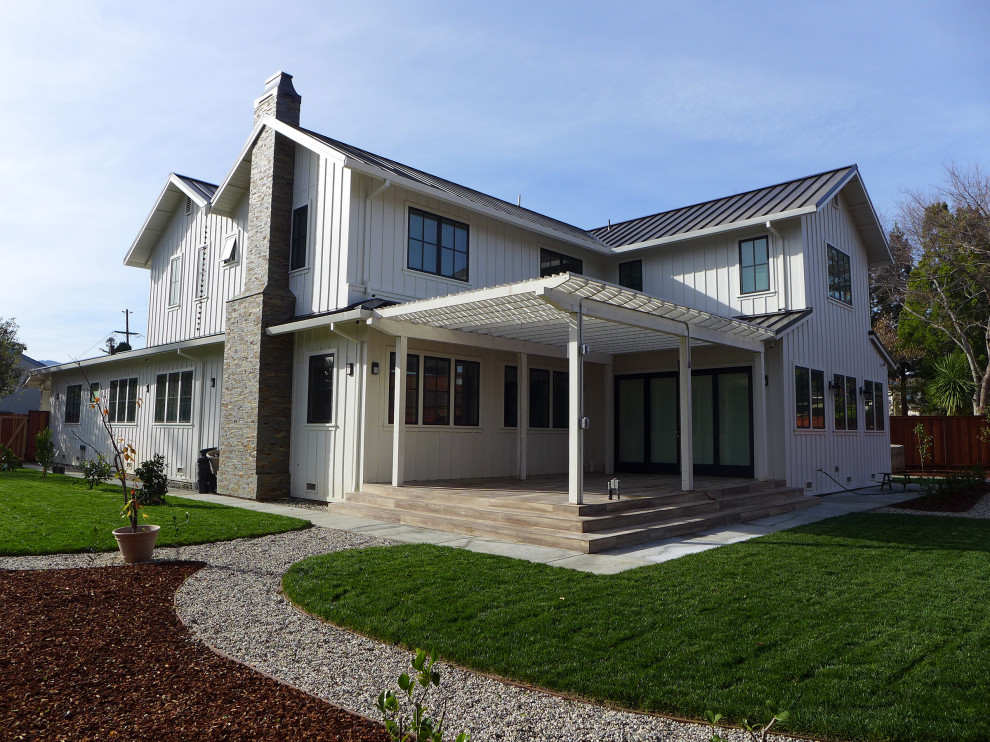 Foto di un ampio patio o portico country dietro casa con pavimentazioni in mattoni e una pergola