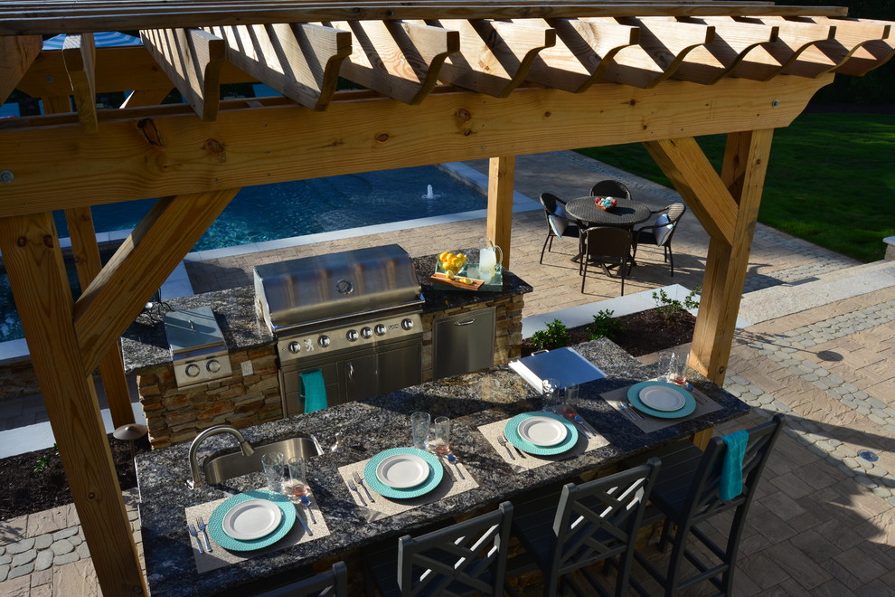 Inspiration pour une grande terrasse arrière craftsman avec une cuisine d'été, des pavés en béton et une pergola.