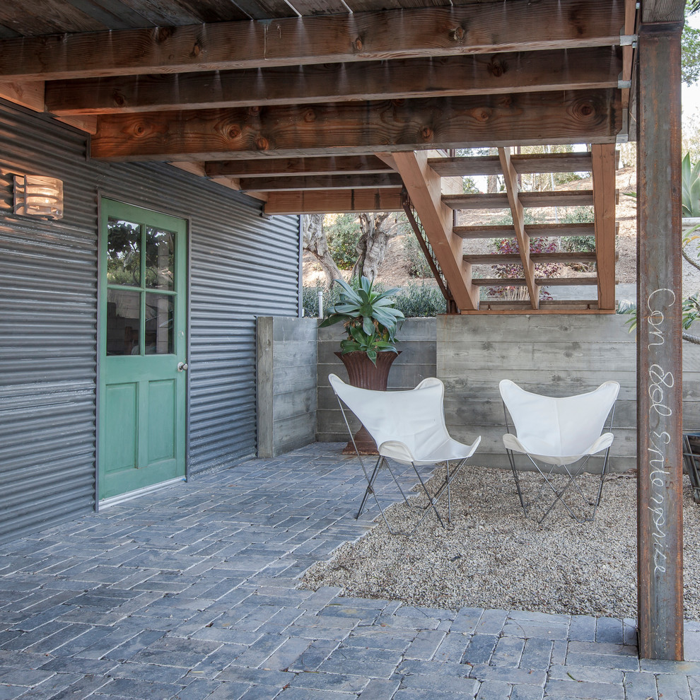 Esempio di un patio o portico minimal dietro casa con pavimentazioni in pietra naturale e un tetto a sbalzo