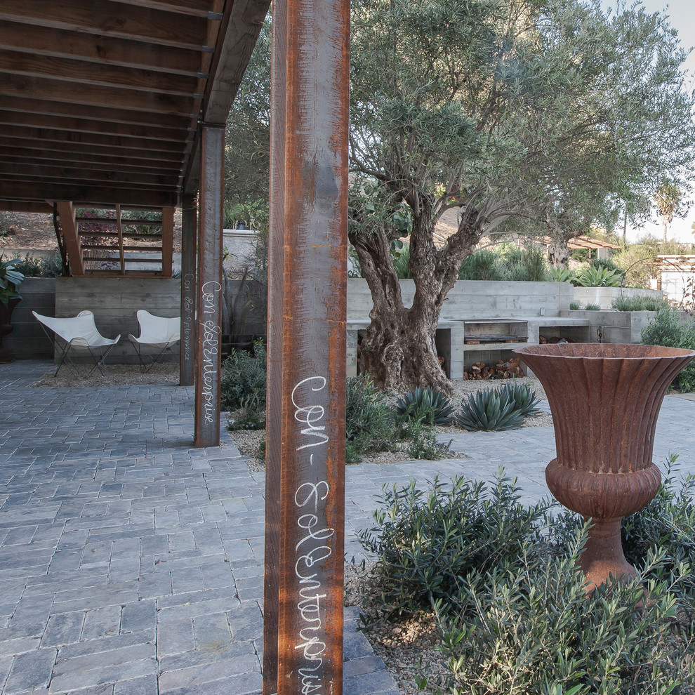 Überdachter Moderner Patio hinter dem Haus mit Natursteinplatten in Los Angeles