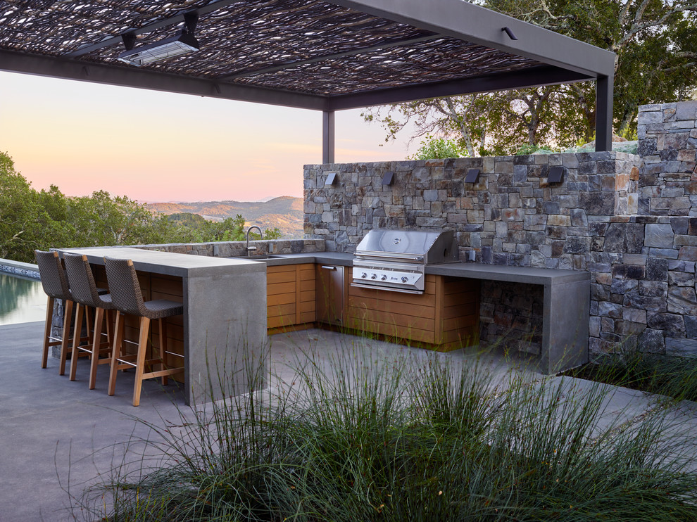 This is an example of a contemporary patio in San Francisco with concrete slabs, a gazebo and a bar area.