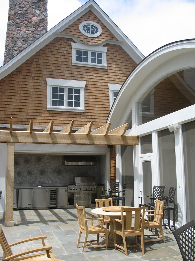 На фото: огромная пергола во дворе частного дома на заднем дворе в классическом стиле с летней кухней и покрытием из каменной брусчатки