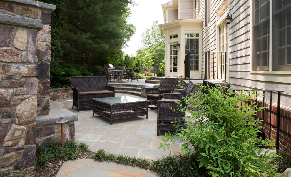 Immagine di un grande patio o portico chic dietro casa con un focolare e pavimentazioni in pietra naturale