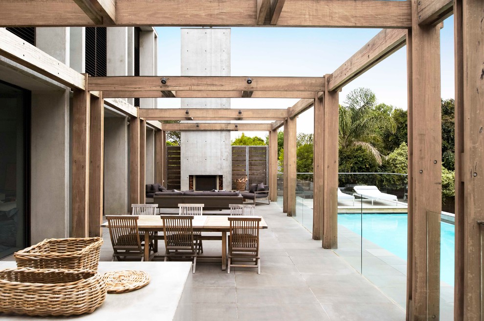 This is an example of a contemporary back patio in Melbourne with a fire feature and a pergola.