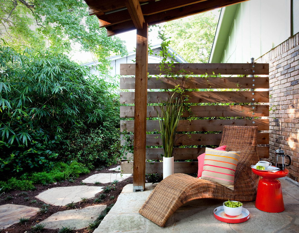 This is an example of a traditional patio in Austin with natural stone paving and fencing.