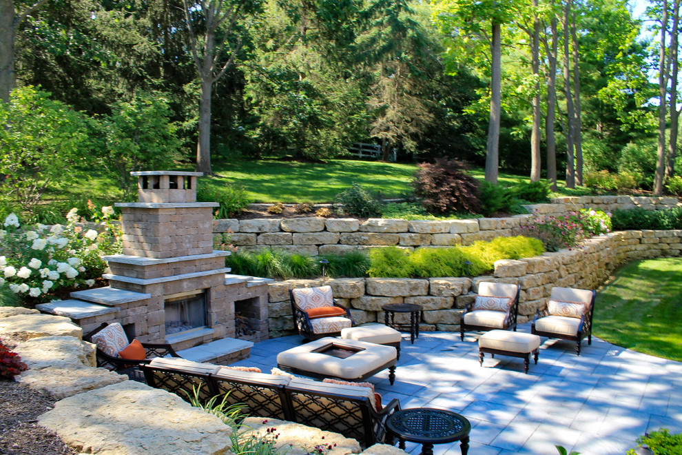 Inspiration for a large traditional back patio in Chicago with a fire feature and natural stone paving.