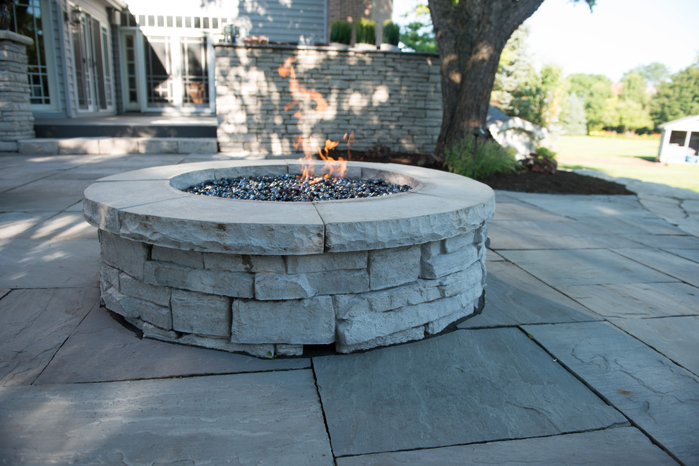 This is an example of a medium sized contemporary back patio in Chicago with a fire feature, concrete paving and no cover.